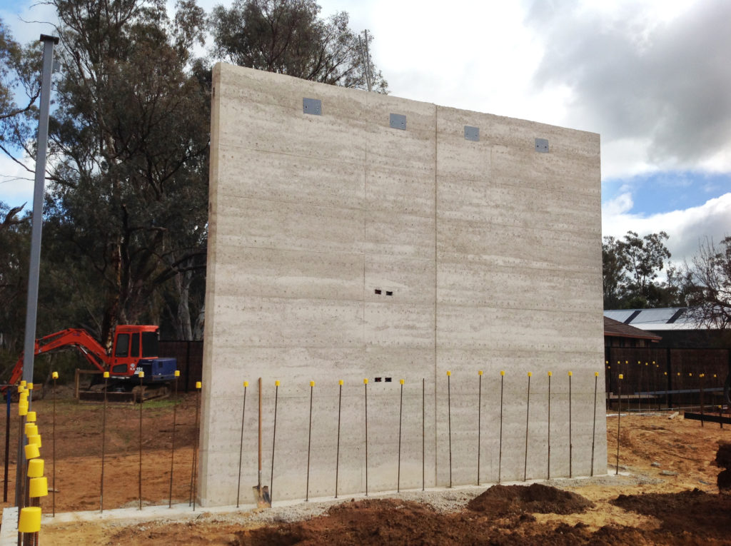 Image of cooler toned grey rammed earth wall just after construction